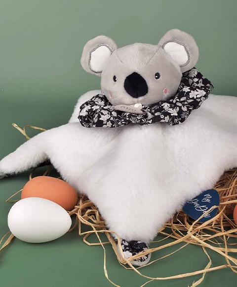 doudou koala gris et blanc se transformant en boule au motif végétal noir