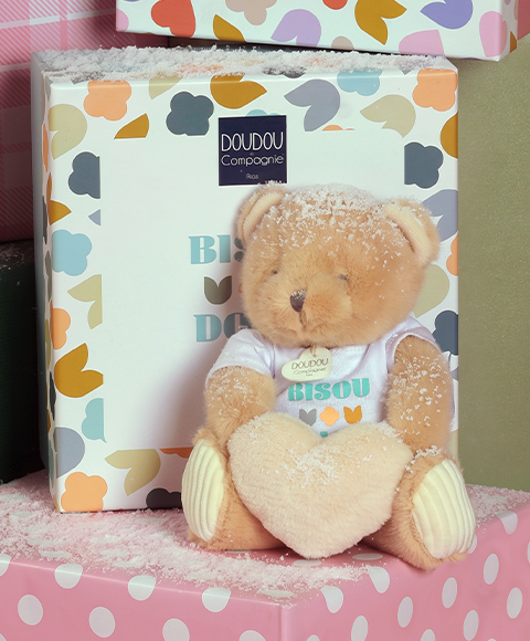 ours en peluche beige assis tenant un coeur beige entre ses pattes unicef